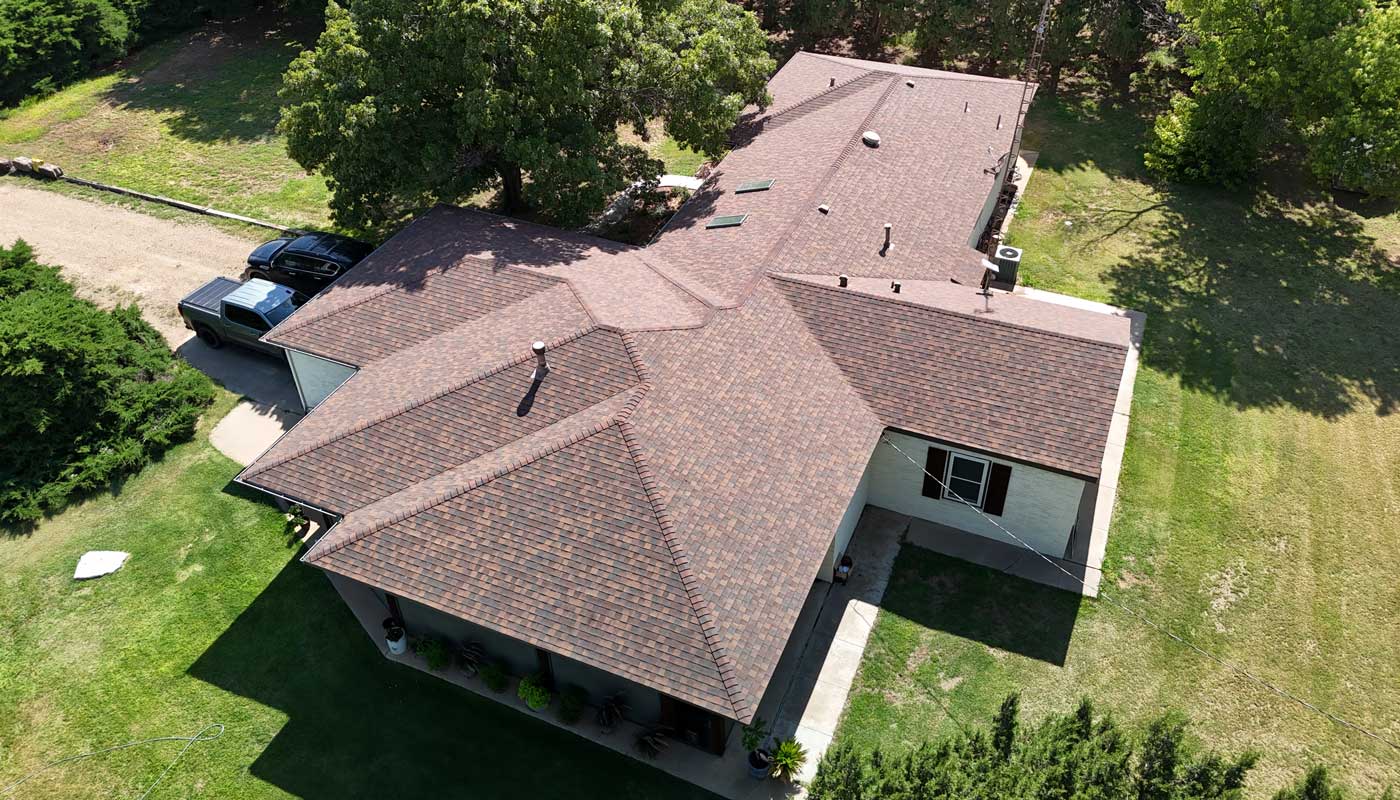 Crew laying fresh architectural shingles across a steep residential roof
